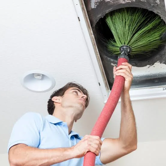 Rotary brush agitating dust inside a ceiling air duct during duct cleaning